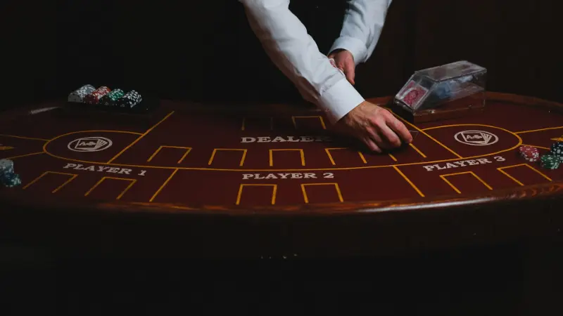 Krupje za temno blackjack mizo, vidne samo roke